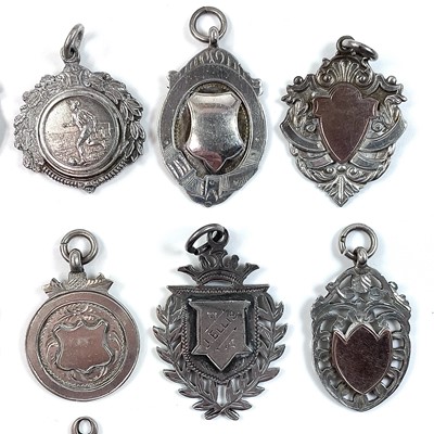 Lot 251 - A collection of thirteen silver shield fobs,...