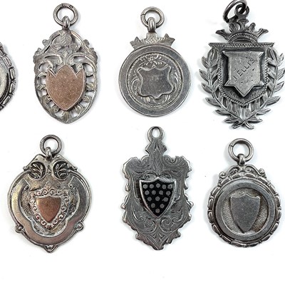 Lot 251 - A collection of thirteen silver shield fobs,...