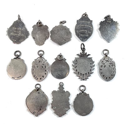 Lot 251 - A collection of thirteen silver shield fobs,...