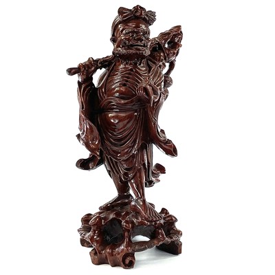 Lot 129 - A Chinese carved wood figure of a man carrying a staff and holding a peach, late 19th century.