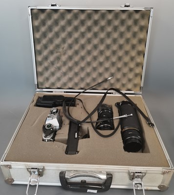 Lot 11 - A cased Canon AE-1 camera with attachments.