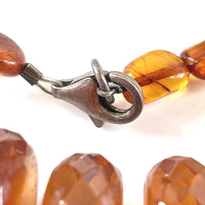 Lot 233 - A faceted honey amber necklace, 71 grams, full...