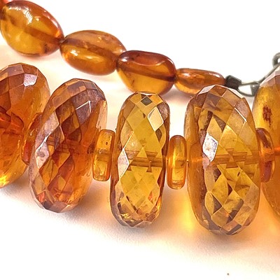 Lot 233 - A faceted honey amber necklace, 71 grams, full...