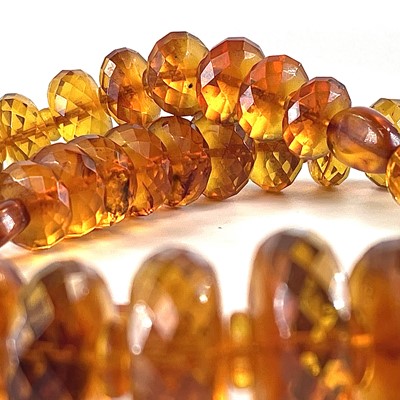 Lot 233 - A faceted honey amber necklace, 71 grams, full...