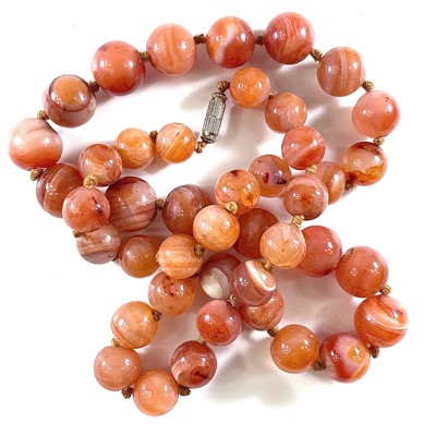 Lot 256 - A carnelian stone bead necklace, length 64cm,...