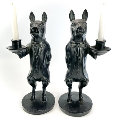 Lot 114 - A pair of ebonised candle holders modelled as...