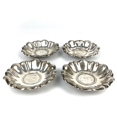 Lot 137 - A set of four Continental silver lobed pin dishes inset with 2 schilling coins.