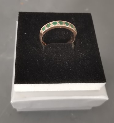 Lot 5 - A 9ct gold ring with set green stones.