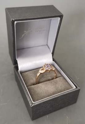 Lot 8 - A 9ct gold ring set with diamonds and a purple...