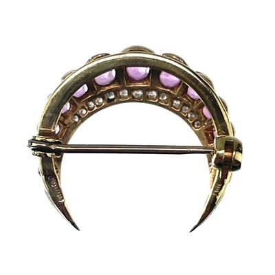 Lot 7 - A modern 9ct gold diamond and ruby crescent brooch