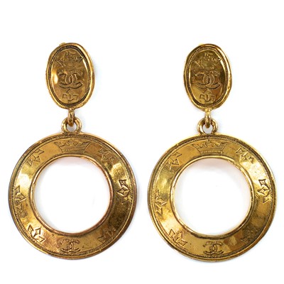 Lot 400 - A pair of Chanel gold plated hoop earrings, with logo design.