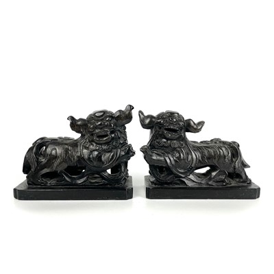 Lot 122 - A pair of Chinese black hardstone models of dogs of fo, early-mid 20th century.