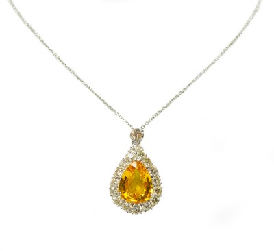 Lot 135 - An 18ct white gold, yellow sapphire and diamond cluster pendant necklace.