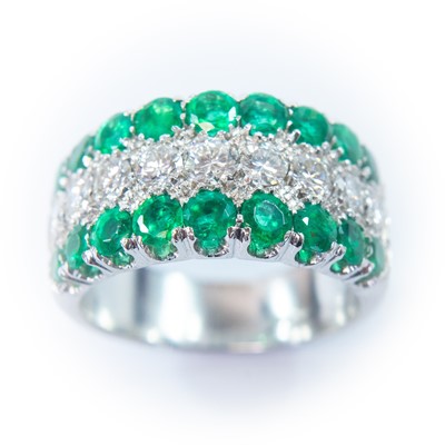 Lot 118 - An 18ct white gold diamond and emerald half eternity ring.