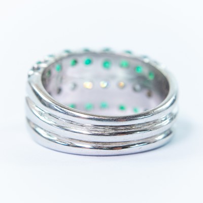Lot 118 - An 18ct white gold diamond and emerald half eternity ring.