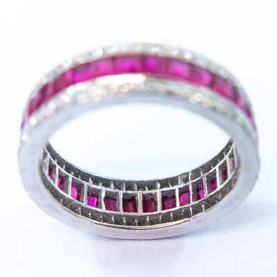 Lot 75 - An 18ct white gold diamond and ruby set full eternity ring.