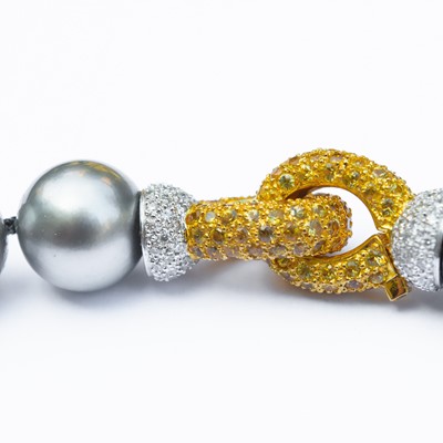 Lot 23 - A grey cultured pearl necklace with 18ct bi-colour gold yellow and white diamond clasp.