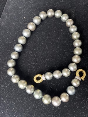 Lot 23 - A grey cultured pearl necklace with 18ct bi-colour gold yellow and white diamond clasp.