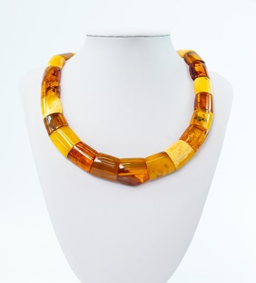 Lot 228 - A contemporary multi-coloured amber panel bead necklace with gold plated button clasp.