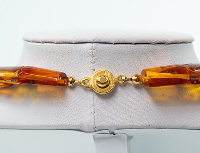 Lot 228 - A contemporary multi-coloured amber panel bead necklace with gold plated button clasp.