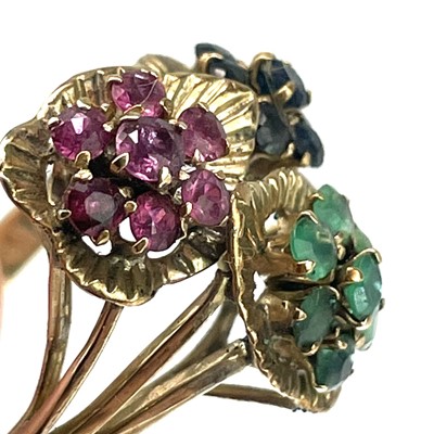 Lot 54 - An 18ct gold emerald, ruby and sapphire set triple daisy head ring.