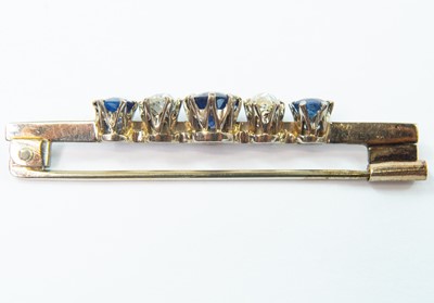 Lot 172 - An 18ct white gold diamond and sapphire set five stone bar brooch.