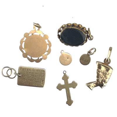 Lot 106 - A Victorian gold small oval pendant and six gold charms.