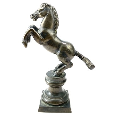 Lot 117 - A brass rearing stallion on a pedestal base,...