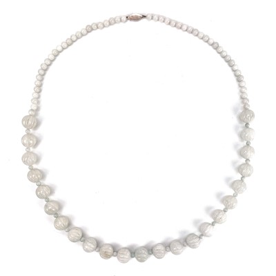 Lot 255 - A white jade necklace with carved graduated beads.