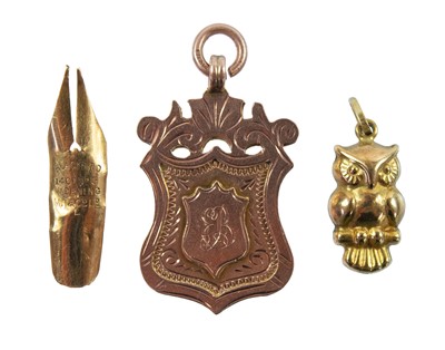 Lot 47 - A 9ct rose gold shield fob, a 9ct gold owl charm and a 14ct pen nib.