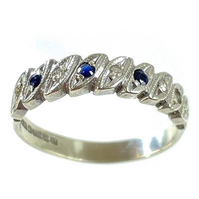 Lot 112 - A 9ct white gold diamond and sapphire eight stone set half eternity ring.