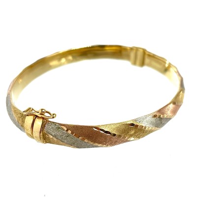 Lot 258 - An Italian 9ct tri-colour gold hinged bangle.