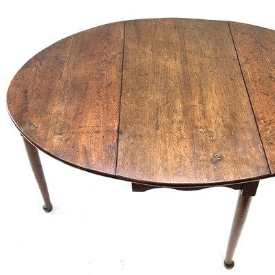 Lot 144 - A Georgian oak drop leaf dining table.