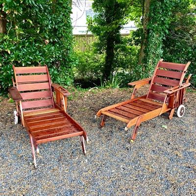 Lot 601 - A pair of teak and brass mounted sun loungers...