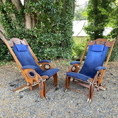 Lot 602 - A pair of teak and brass mounted deck chairs...