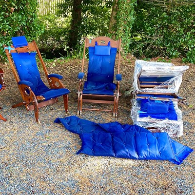 Lot 603 - A pair of teak and brass mounted deck chairs...