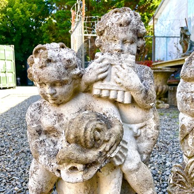 Lot 605 - A reconstituted stone fountain, modelled as putti playing pan pipes.