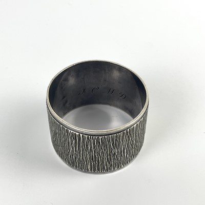 Lot 58 - A modern silver heavy napkin ring with textured design by Mappin & Webb.