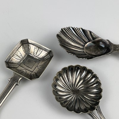 Lot 57 - A George V silver caddy spoon with shell bowl and two continental silver caddy spoons.