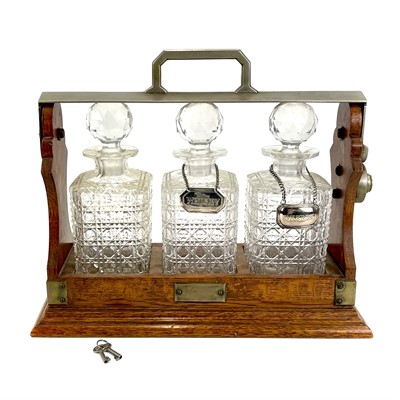 Lot 122 - An Edwardian oak three bottle tantalus.