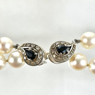 Lot 338 - A Swedish cultured pearl necklace with double 18ct white gold diamond and sapphire cluster clasps.