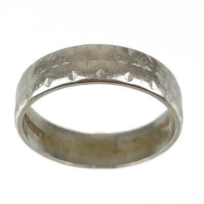 Lot 192 - A platinum band ring with engraved decoration.