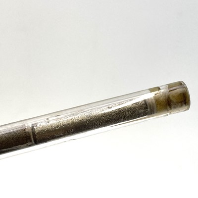 Lot 184 - A modern glass boiler tube displaying cassiterite at the various stages of processing.