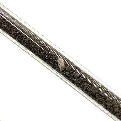 Lot 184 - A modern glass boiler tube displaying cassiterite at the various stages of processing.