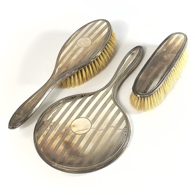 Lot 99 - A George V silver three piece dressing table set.