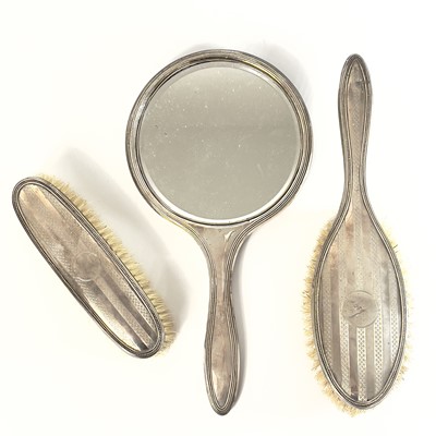 Lot 99 - A George V silver three piece dressing table set.