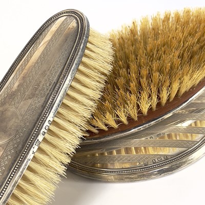 Lot 99 - A George V silver three piece dressing table set.