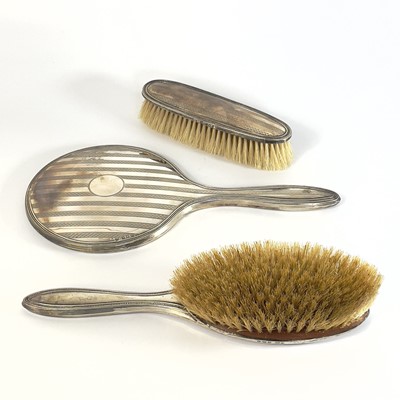Lot 99 - A George V silver three piece dressing table set.