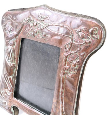 Lot 60 - An Art Nouveau copper picture frame with repousse decoration of a maiden picking apples.