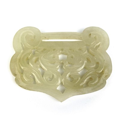 Lot 12 - A Chinese carved pale jade buckle, Qing Dynasty.